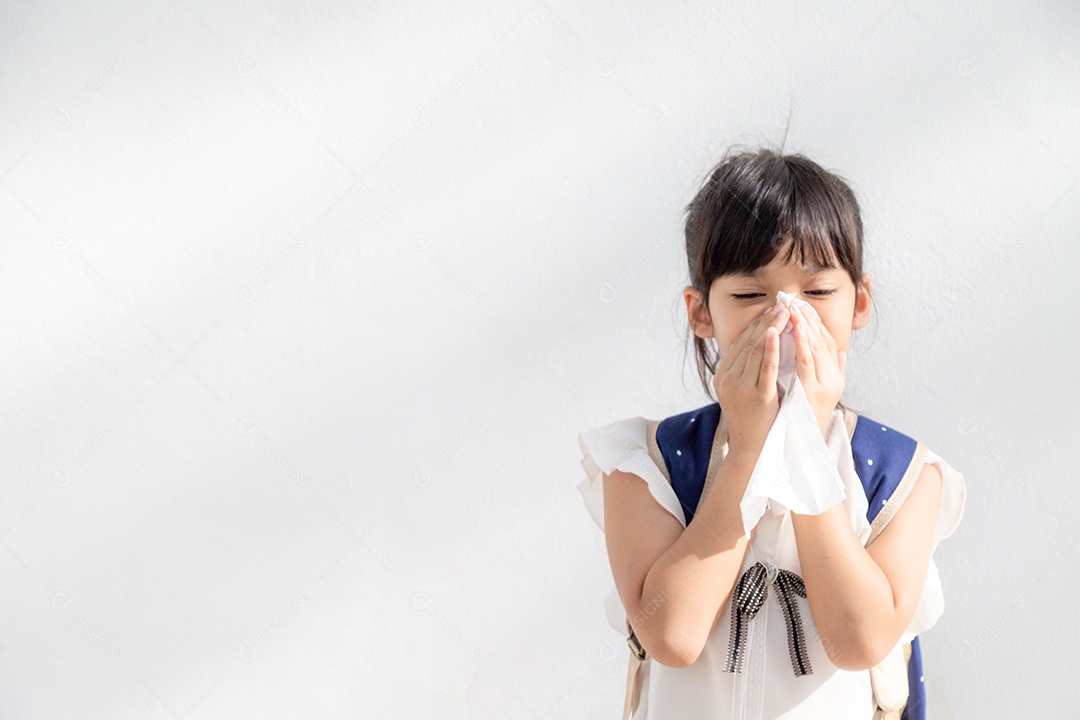 Menina asiática doente com espirros no nariz e tosse