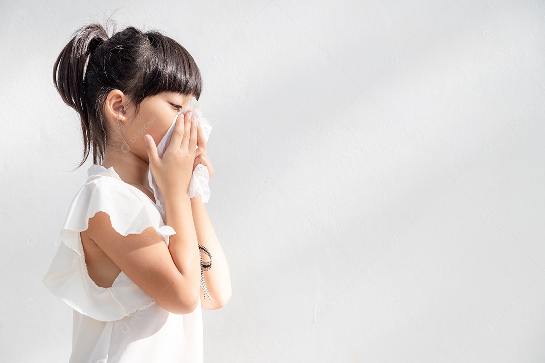 Menina asiática doente com espirros no nariz e tosse fria