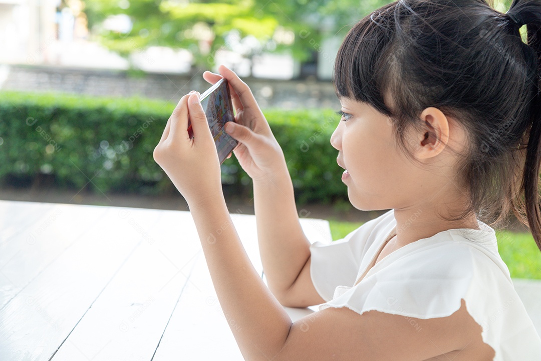 Menina asiática usando telefone inteligente no café. Estilo de vida ao ar livre de luz natural.