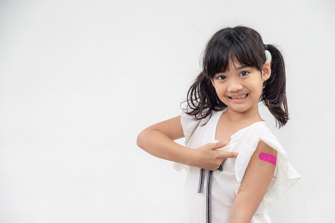 Asian girl showing her arm after being vaccinated or inoculated
