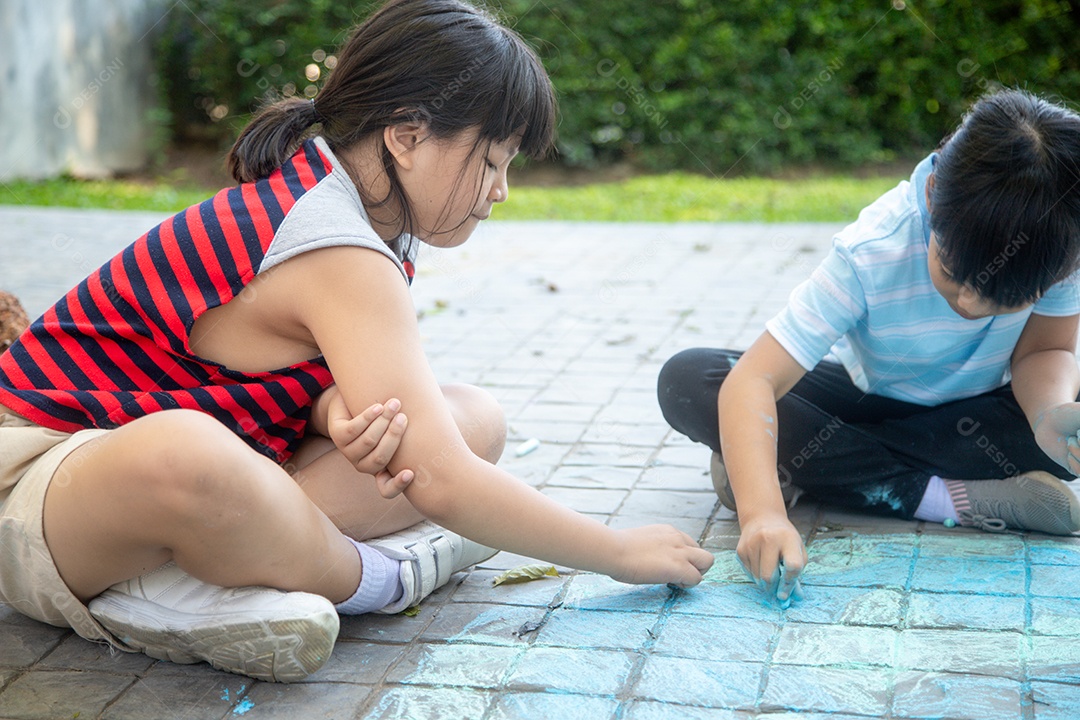 Crianças asiáticas brincam ao ar livre. A menina da criança desenha um wi do globo do planeta