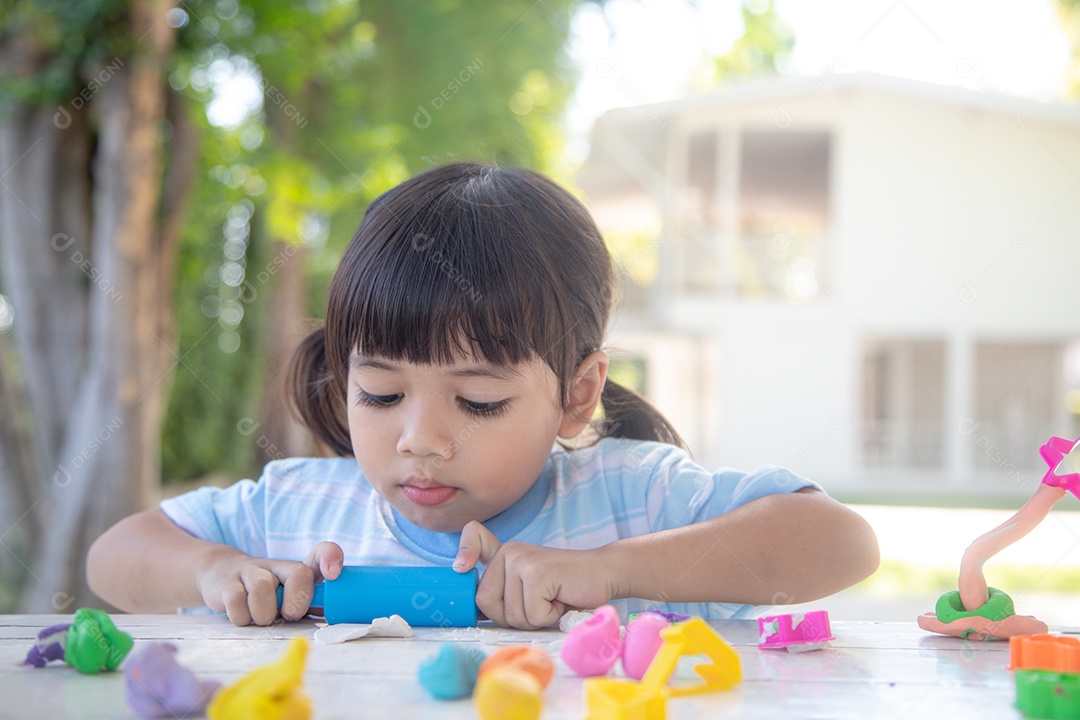 Criança asiática brincam com formas de moldagem de argila, aprendendo brincando