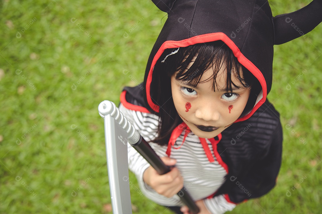 Feliz Dia das Bruxas! A menina bonitinha na fantasia de Halloween