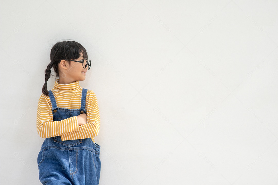 Linda garotinha asiática usando óculos e pensando