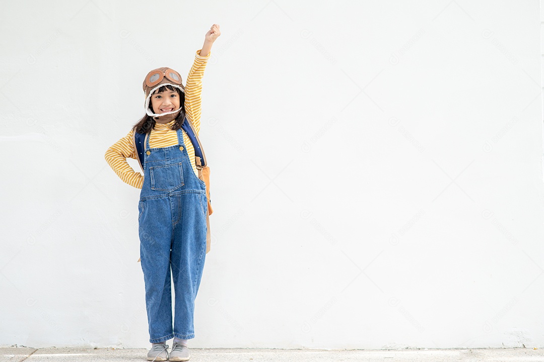 Uma menina bonitinha vestida com um boné e óculos de piloto