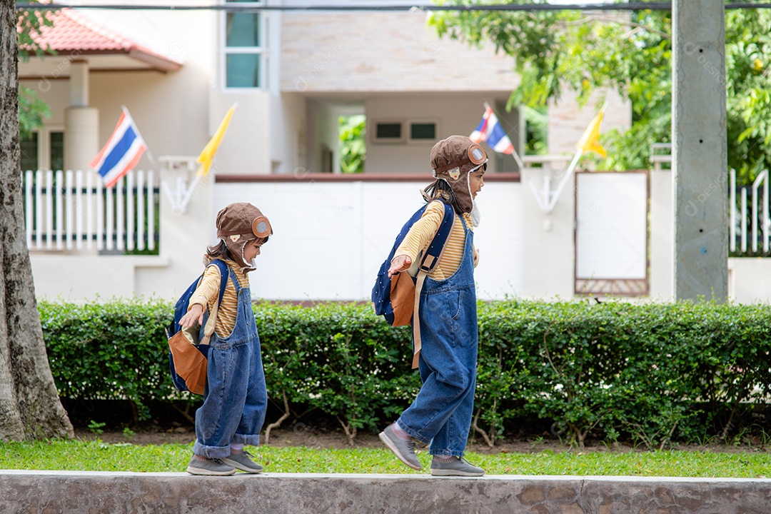 Uma menina bonitinha vestida com um boné e óculos de piloto