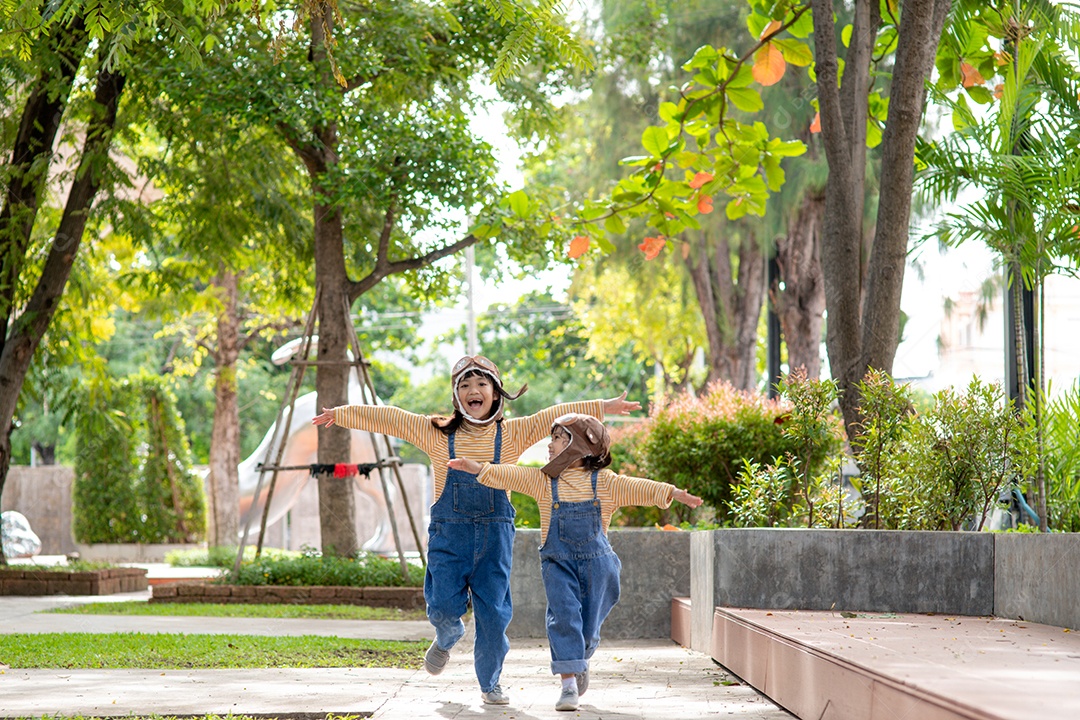 Uma menina bonitinha vestida com um boné e óculos de piloto