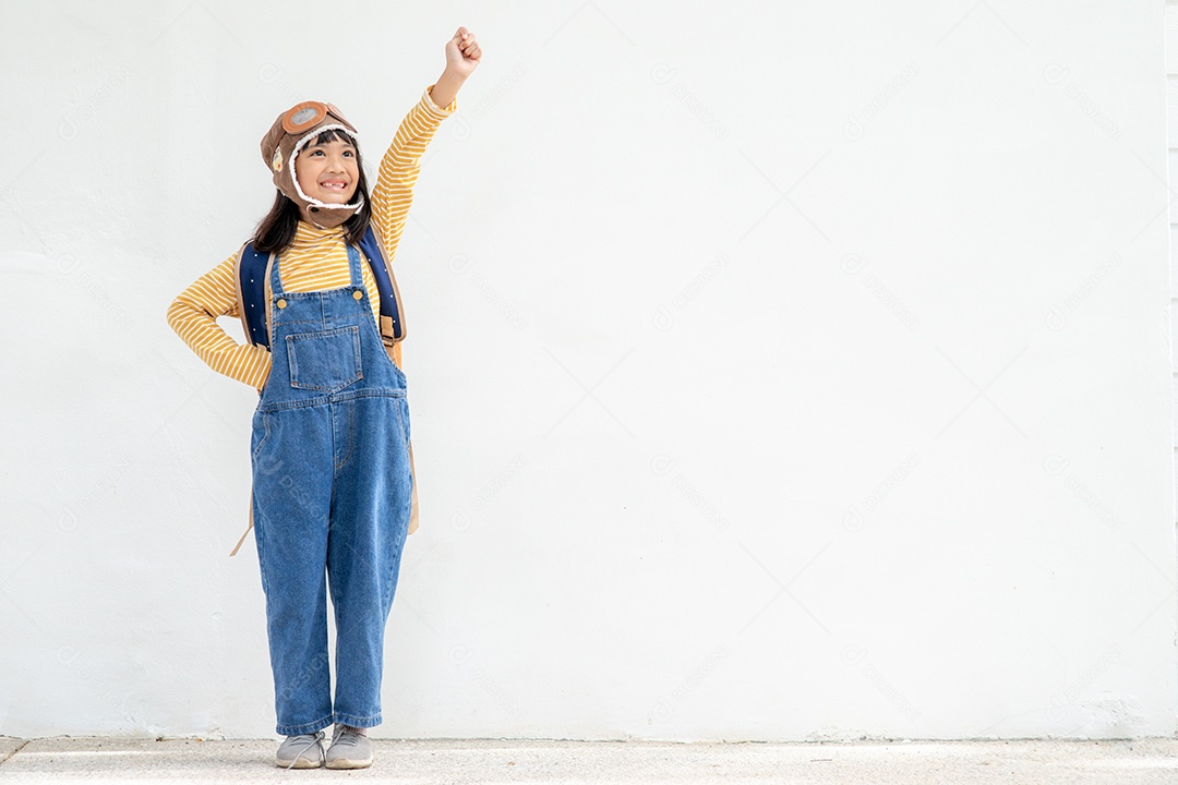 Uma menina bonitinha vestida com um boné e óculos de piloto