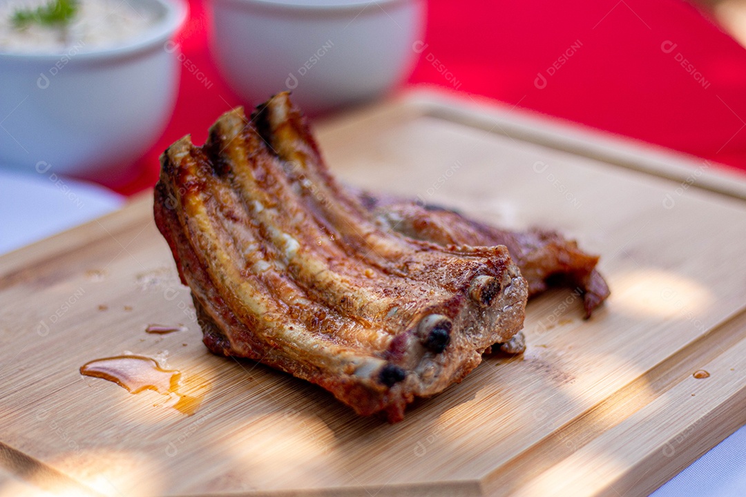 Carne assada costela sobre uma tabua de madeira