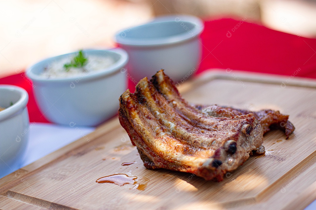 Carne assada costela sobre uma tabua de madeira