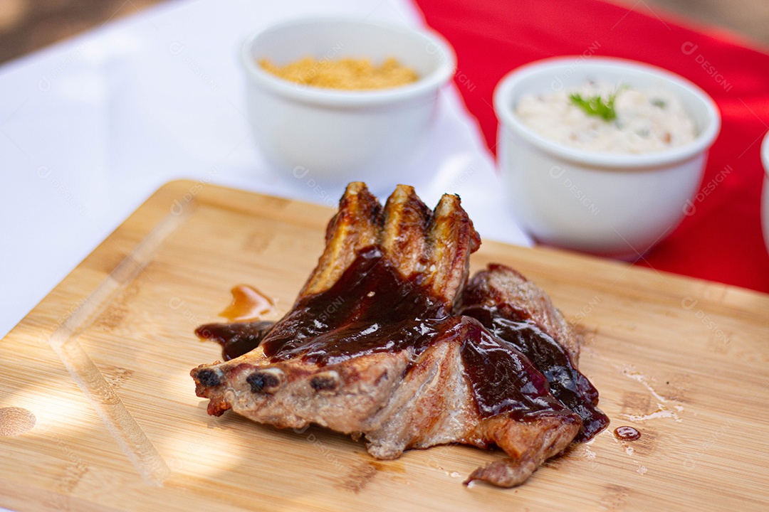 Carne assada costela sobre uma tabua de madeira