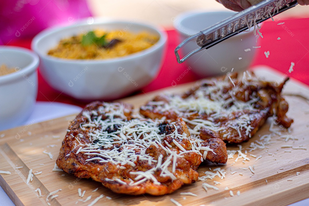 Carne assada costela com queijo ralado sobre uma tabua de madeira