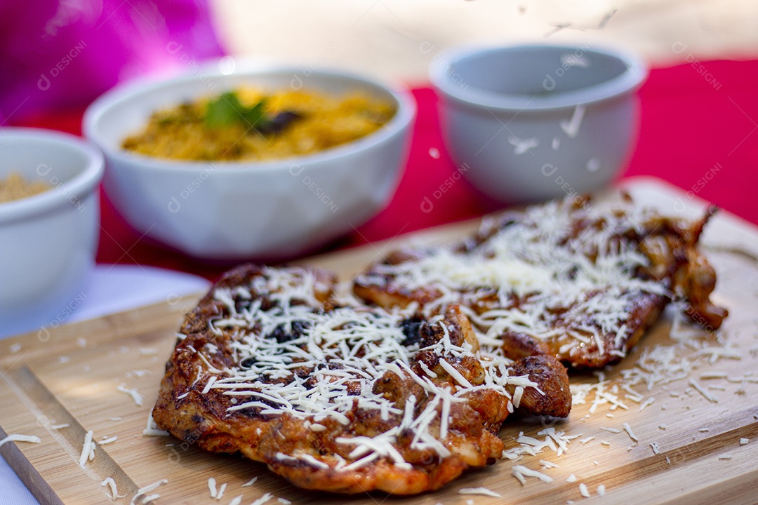 Carne assada costela com queijo ralado sobre uma tabua de madeira