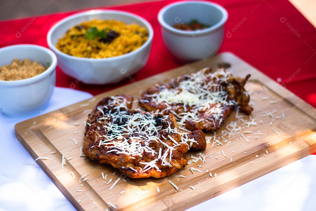 Carne assada costela com queijo ralado sobre uma tabua de madeira