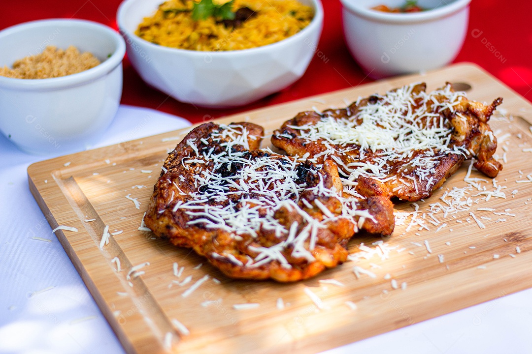 Carne assada costela com queijo ralado sobre uma tabua de madeira