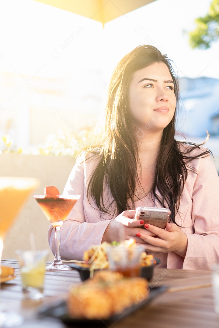 Jovem mulher usando smartphone na mesa do restaurante com amigos