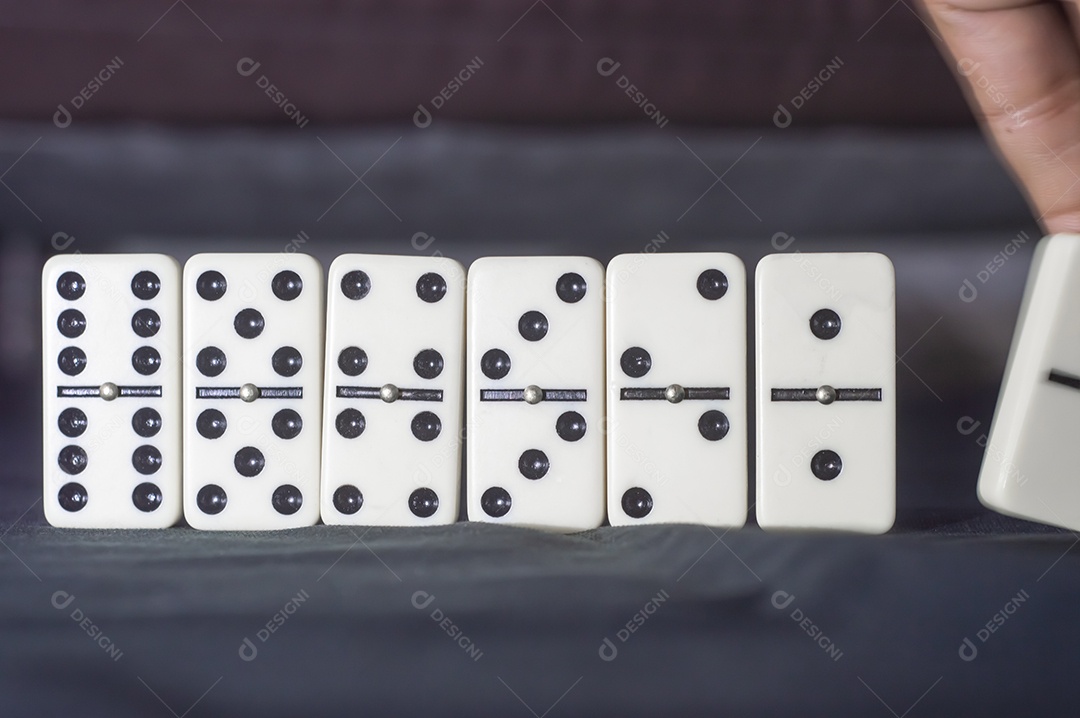 Várias peças de dominó posicionadas em um fundo preto com luz