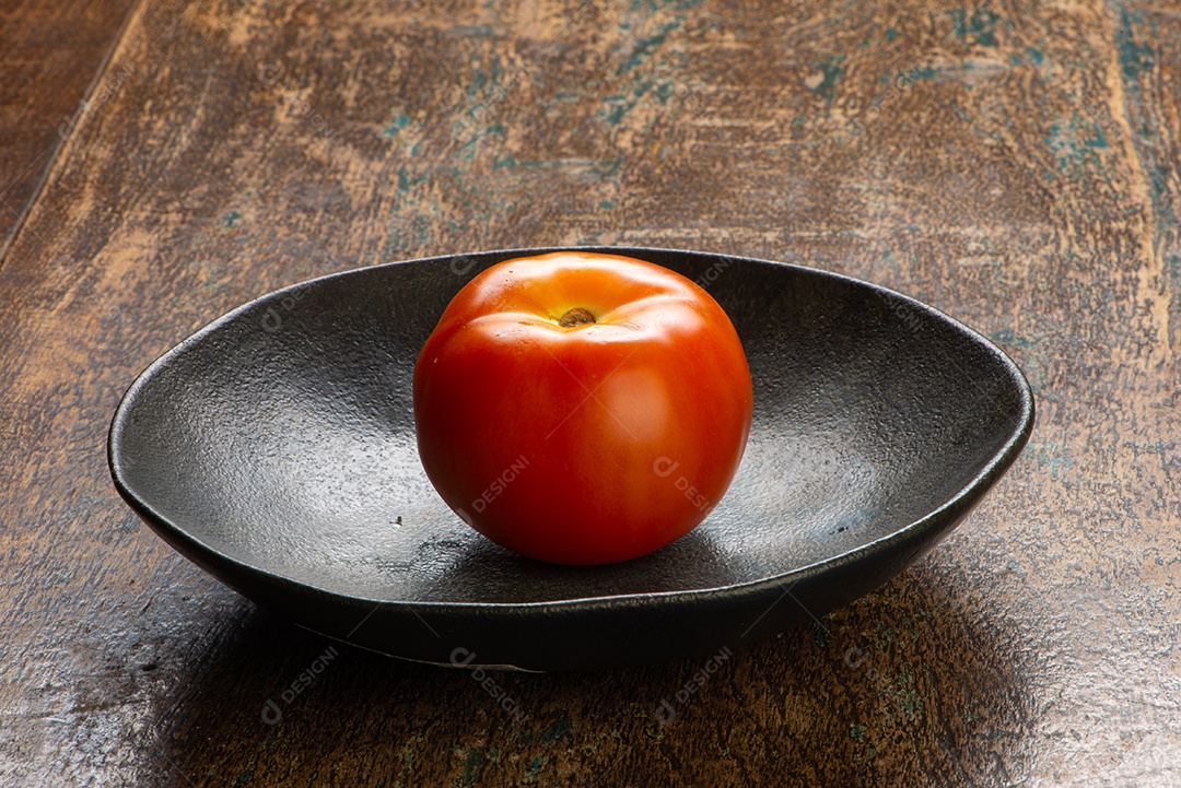 Tomate sobre uma frigideira mesa madeira