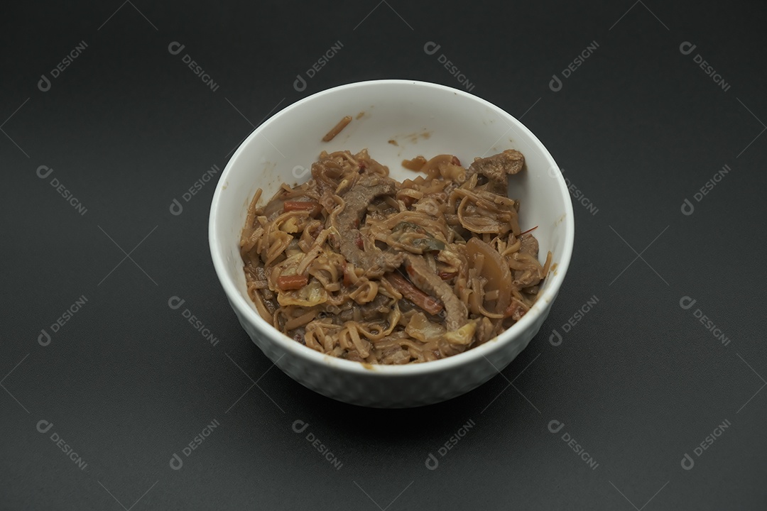 Carne com cebola em tigela branca na mesa branca.