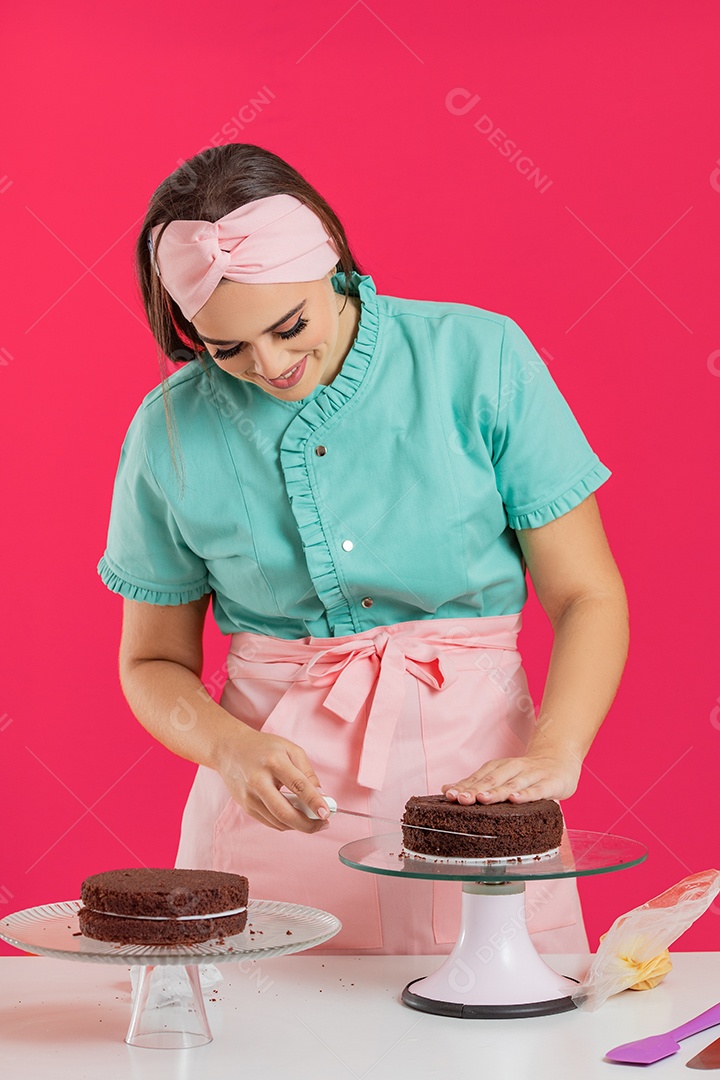Linda mulher jovem chefe de cozinha preparando bolo