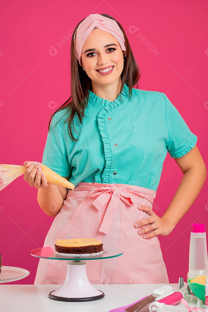 Linda mulher jovem chefe de cozinha preparando bolo