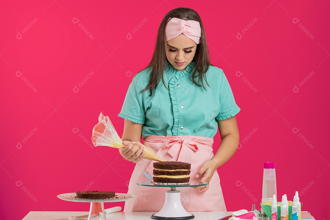 Linda mulher jovem chefe de cozinha preparando bolo