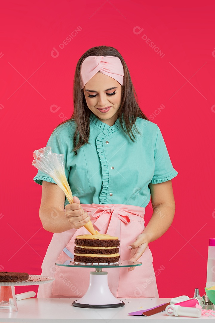 Linda mulher jovem chefe de cozinha preparando bolo