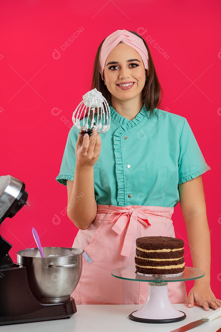 Linda mulher jovem chefe de cozinha preparando bolo