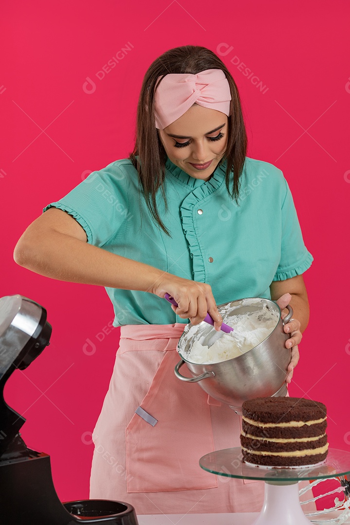 Linda mulher jovem chefe de cozinha preparando bolo