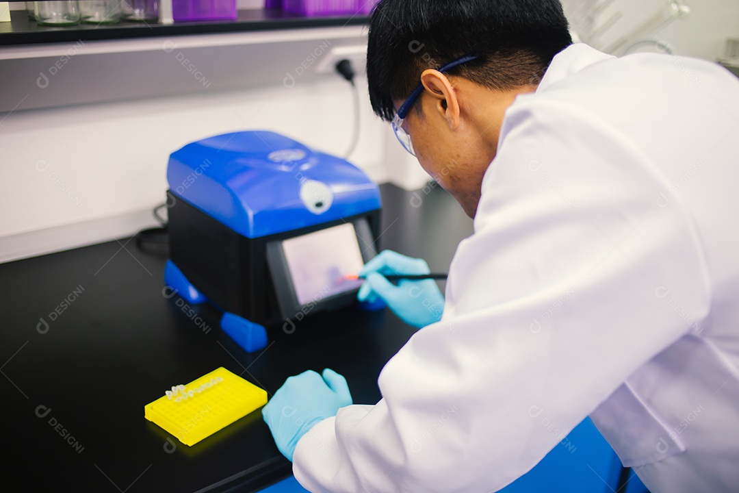 Técnico de laboratório em óculos de proteção e luvas microscópio no laboratório.