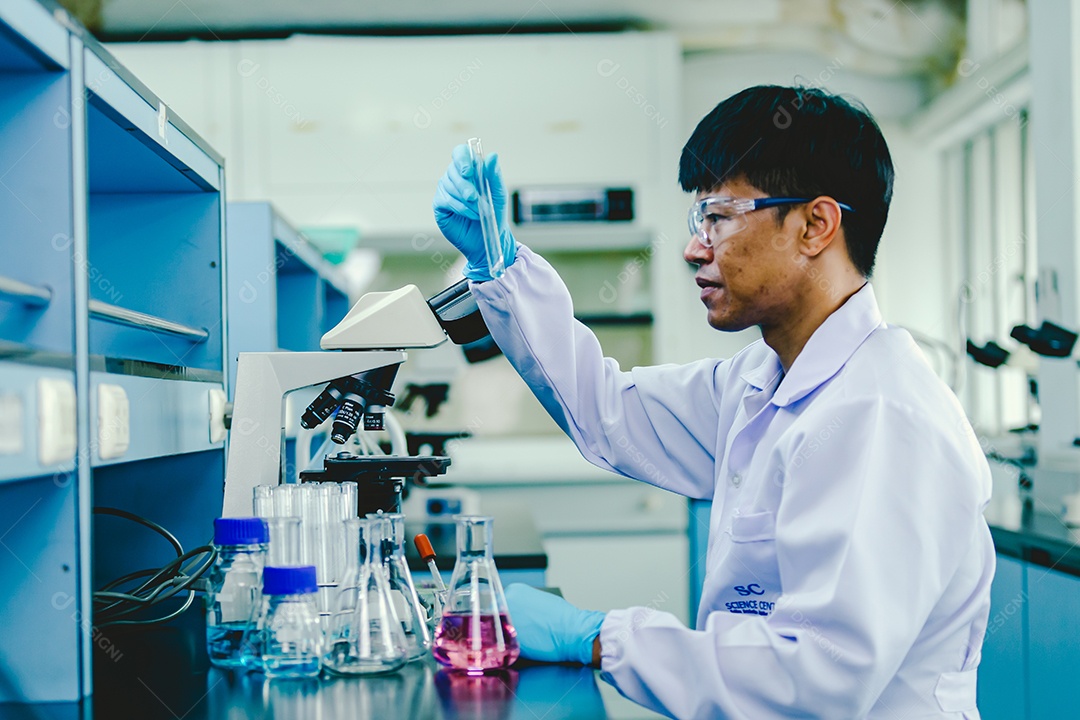 Técnico de laboratório em óculos de proteção e luvas microscópio no laboratório.