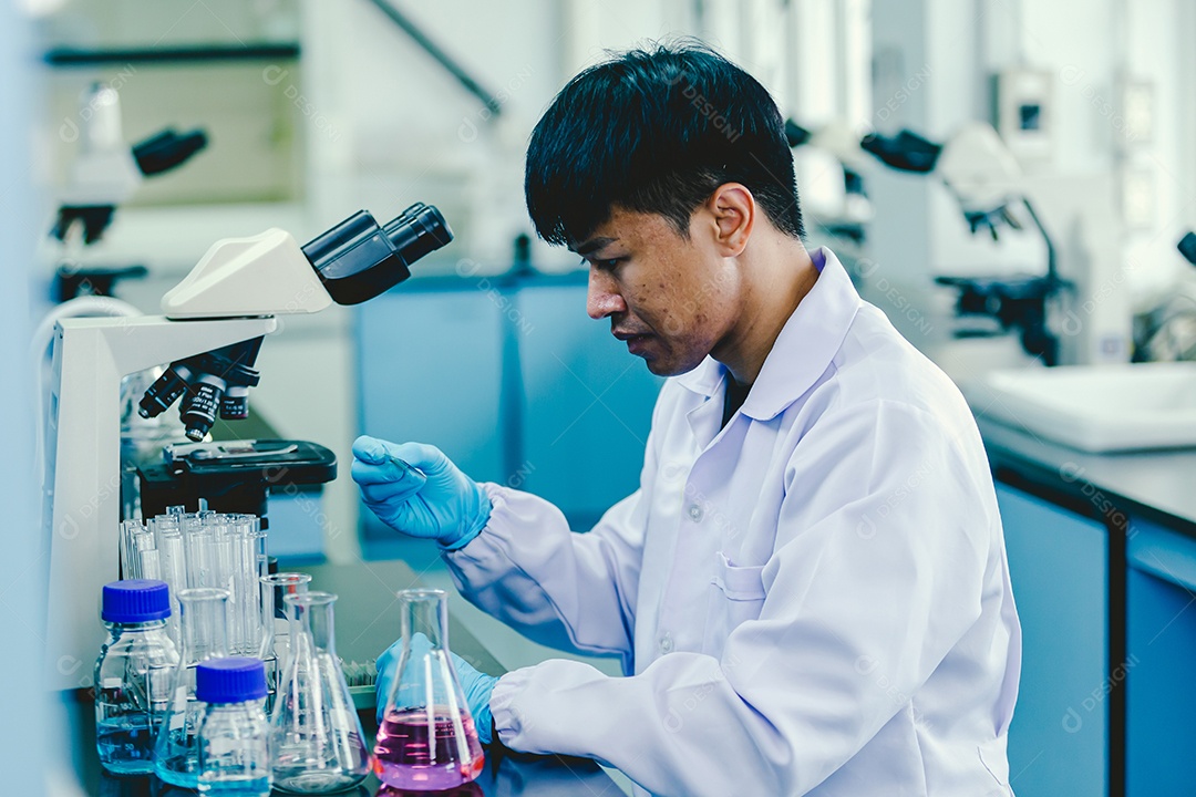 Técnico de laboratório em óculos de proteção e luvas microscópio no laboratório.