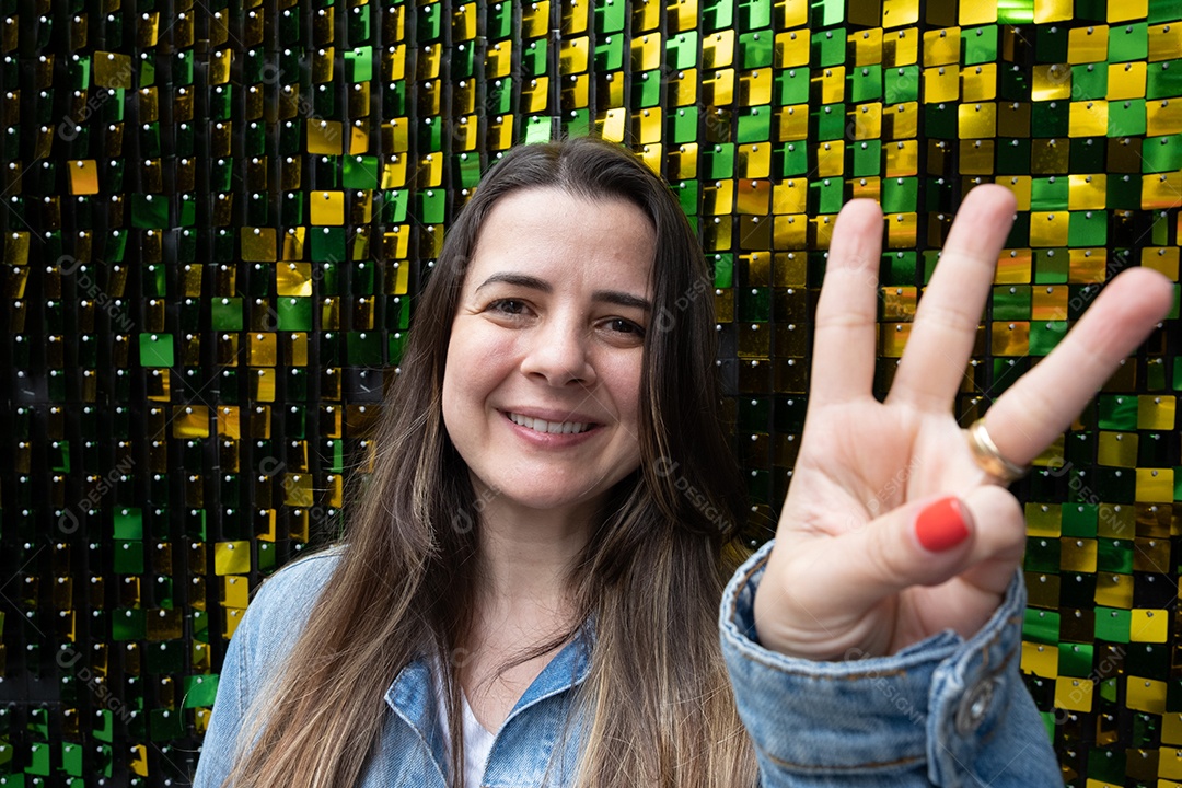 Mulher morena sorrindo na frente de backg verde e amarelo brilhante.