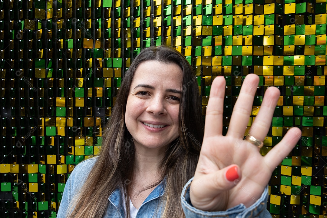 Mulher morena sorrindo na frente de bac verde e amarelo brilhante.