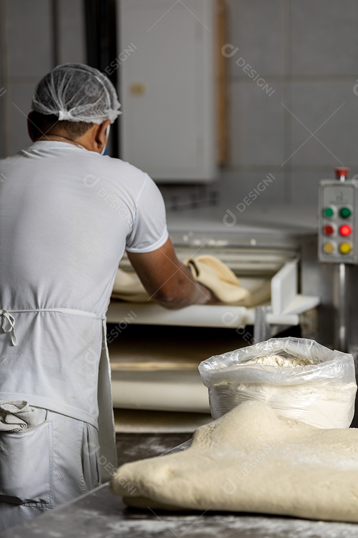 Mãos de homem pegando farinha branca sobre um saco plástico