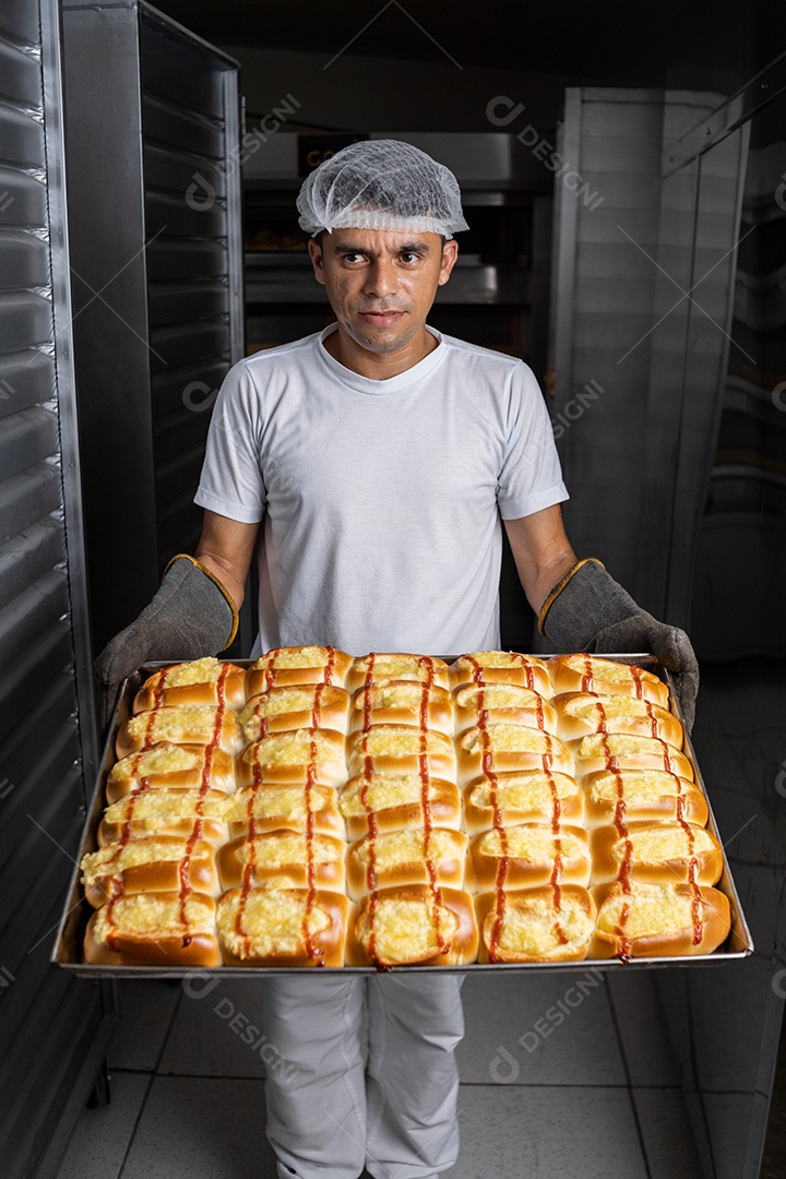 Homem segurando uma forma repleta de pães recheados assados