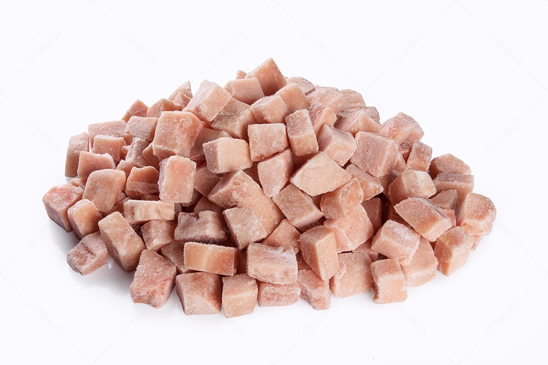 Cubos de carne de frango congelados isolados no fundo branco.
