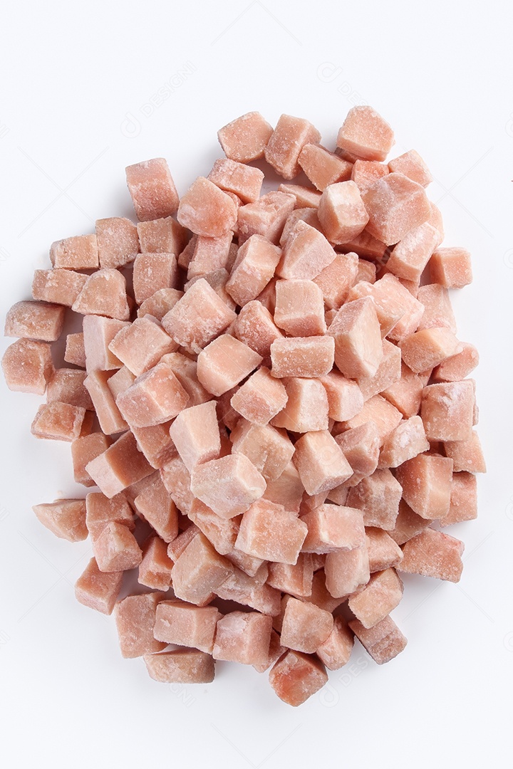 Cubos de carne de frango congelados isolados no fundo branco.
