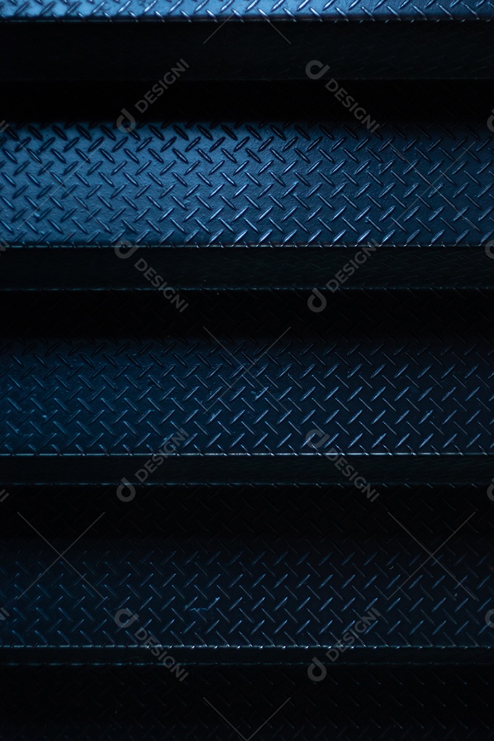 Degraus de uma escada de ferro preto com luz azul.