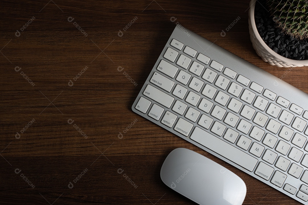 Mesa de madeira escura marrom com mouse de computador branco sem fio