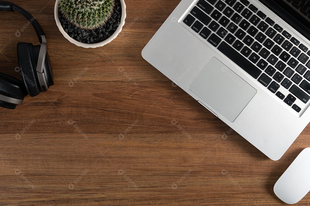 Mesa de madeira marrom escura com computador portátil, mouse limpo, fone de ouvido