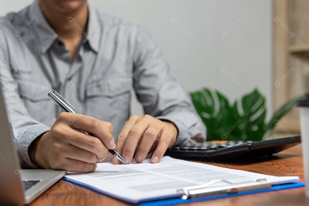 Mão segurando a caneta escrevendo papelada documento de negócios investimento financeiro.