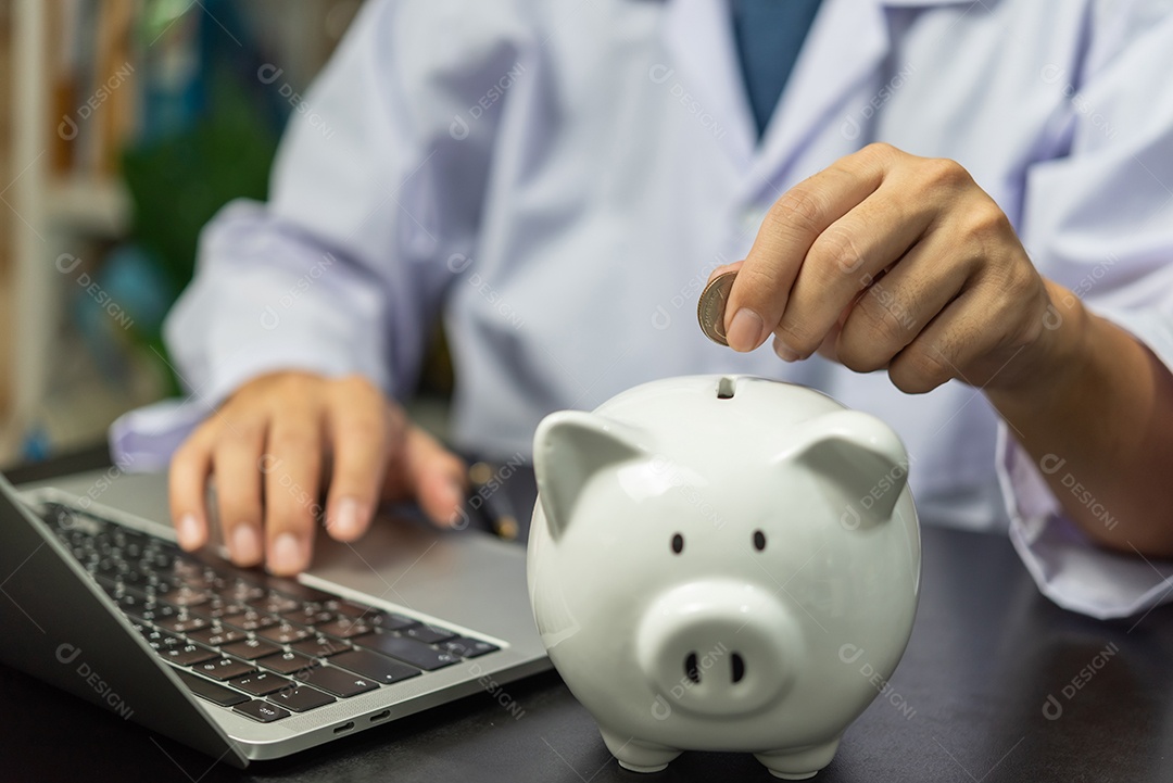 A mão do médico colocou moedas no cofrinho economizando dinheiro seguro e planejando o conceito de negócios de finanças.