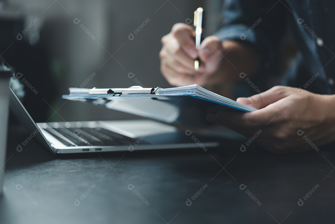 Mão de empresário segurando o relatório de gráfico de papelada de caneta e documento de marketing de investimento gráfico financeiro ou seguro fiscal na mesa.