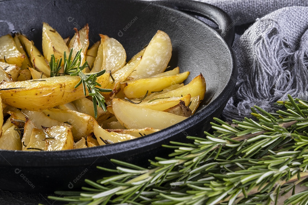 Batatas assadas na caçarola de ferro com alecrim e azeite.