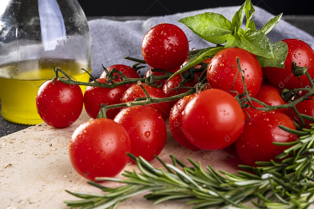 bando de tomates com folhas de manjericão e ramos de alecrim.