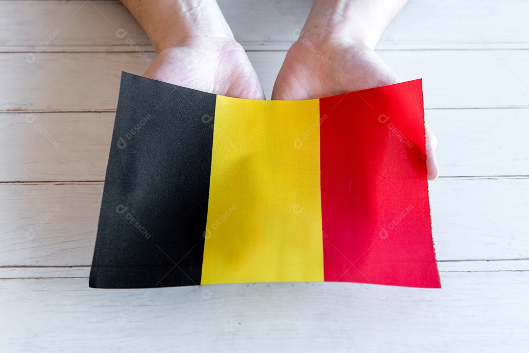 Mãos segurando a bandeira da Bélgica
