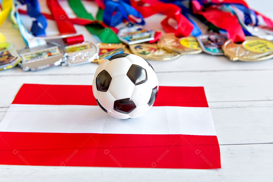 Bola de futebol e bandeira da Áustria, medalhas borradas no fundo