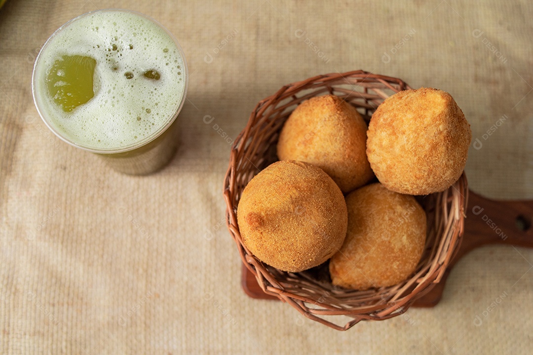 Cesta com salgados servido com um copo de caldo de cana