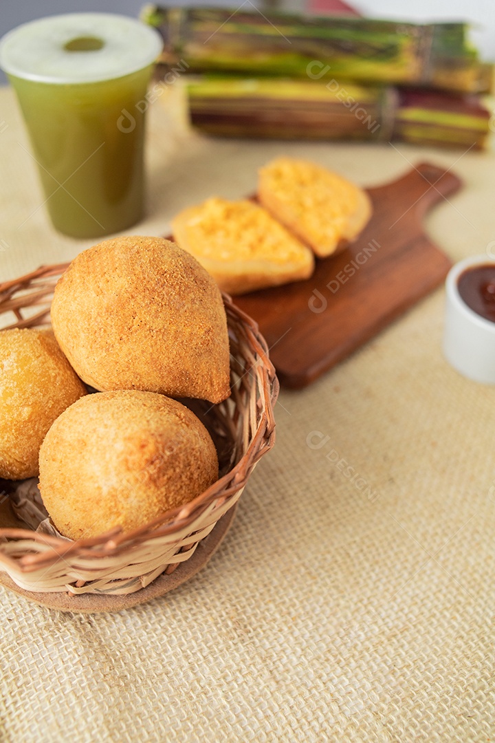 Salgados servidos com um copo de garapa